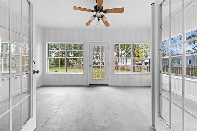 unfurnished sunroom featuring ceiling fan