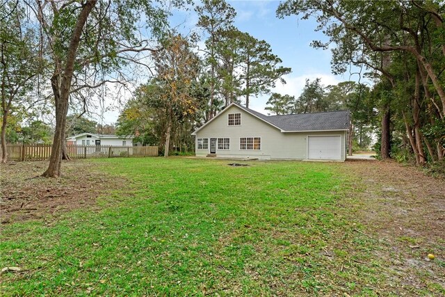 back of property with a lawn and a garage