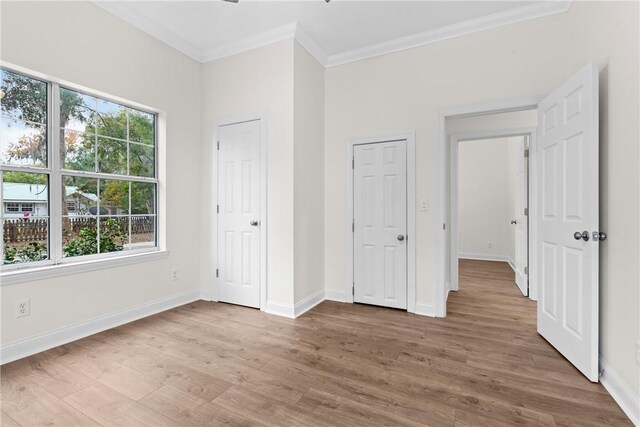 unfurnished bedroom featuring ornamental molding and hardwood / wood-style flooring