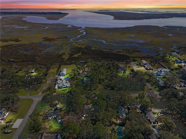 aerial view at dusk featuring a water view