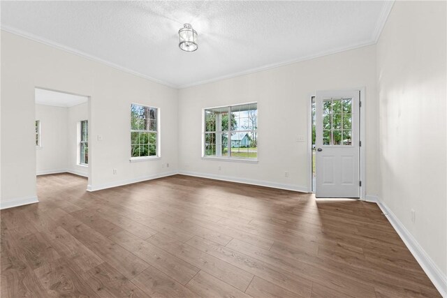 unfurnished living room featuring a textured ceiling, dark hardwood / wood-style floors, and crown molding