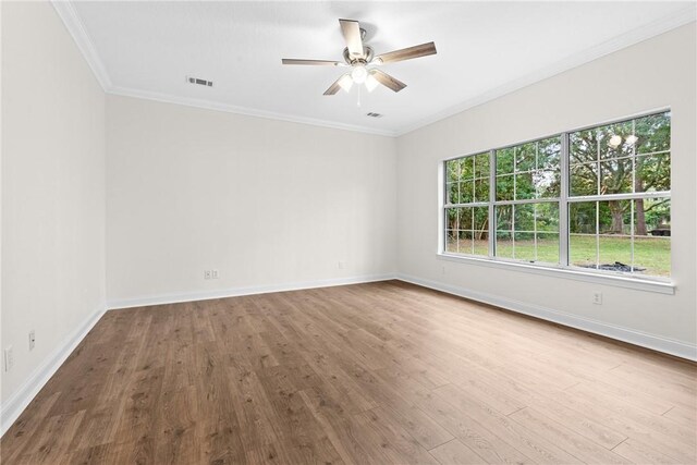 empty room with hardwood / wood-style flooring, ceiling fan, and crown molding