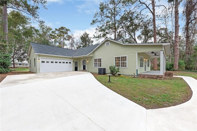 ranch-style house with a front yard, a porch, cooling unit, ceiling fan, and a garage