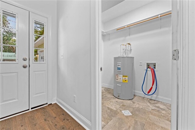 interior space with electric water heater and light hardwood / wood-style flooring