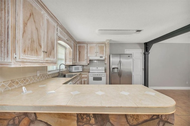 3429 US Highway 82, Brunswick, GA 31523 - kitchen featuring white appliances, a sink, under cabinet range hood, tasteful backsplash, and a peninsula