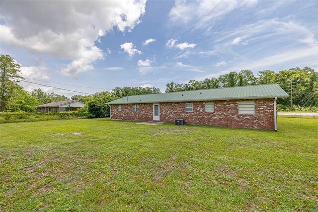 3429 US Highway 82, Brunswick, GA 31523 - back of property featuring a yard, central AC unit, brick siding, and metal roof