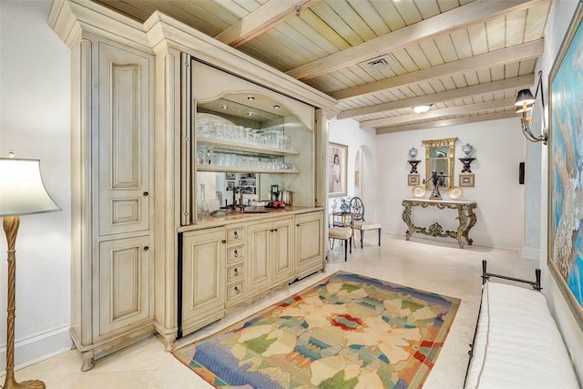 bar featuring beam ceiling, sink, cream cabinets, light tile patterned floors, and wood ceiling