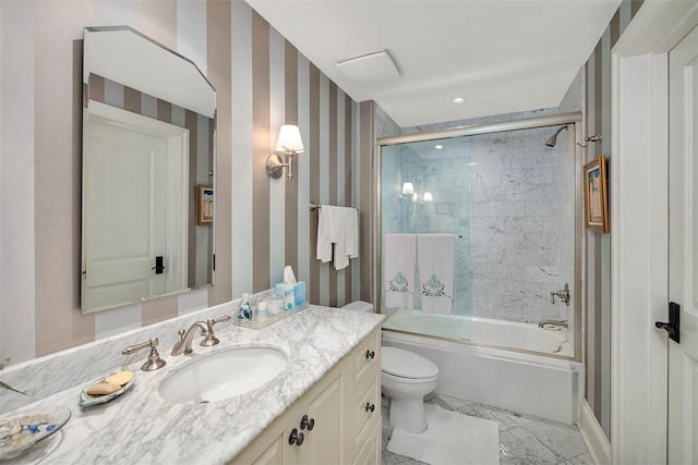 full bathroom featuring vanity, enclosed tub / shower combo, and toilet