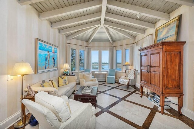 living room featuring lofted ceiling with beams and a water view