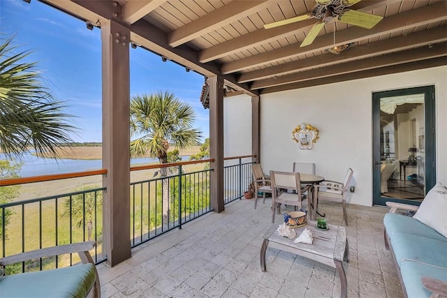 balcony featuring a water view and ceiling fan