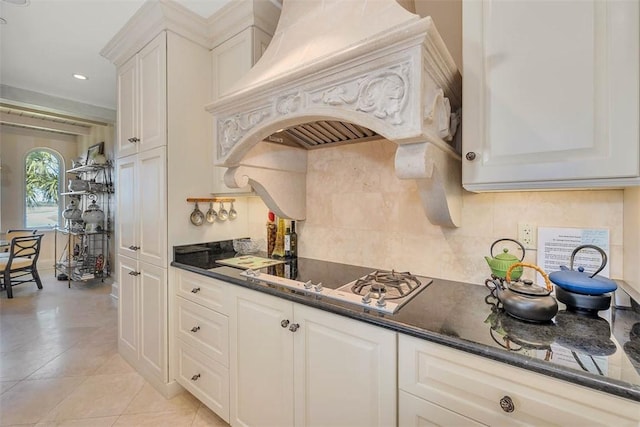 kitchen with custom exhaust hood, decorative backsplash, white cabinetry, and stainless steel gas cooktop