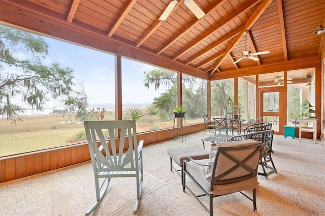 sunroom / solarium featuring a ceiling fan, lofted ceiling with beams, and wood ceiling