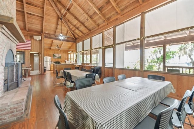 dining room featuring a wealth of natural light, wood-type flooring, wood ceiling, and wood walls