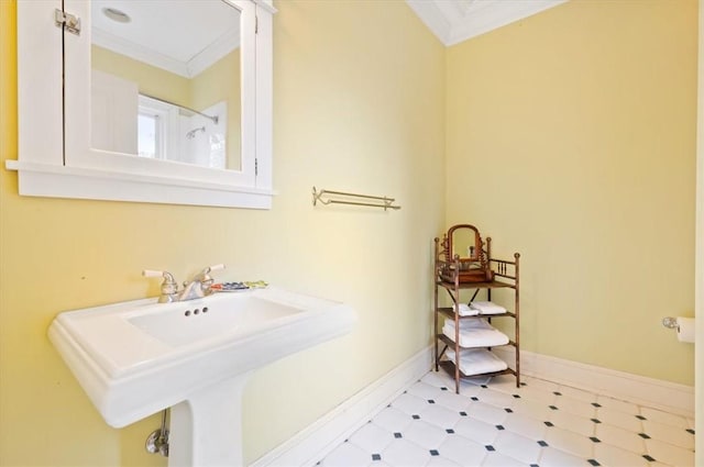 bathroom featuring tile patterned floors, ornamental molding, baseboards, and a sink