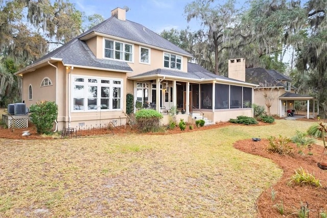 rear view of house with a yard, a sunroom, a chimney, crawl space, and central air condition unit