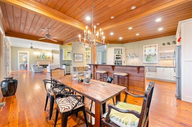 dining space with light wood-style flooring, wooden ceiling, and ornamental molding