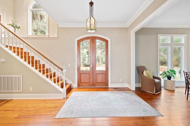 entryway with stairway, visible vents, arched walkways, french doors, and wood-type flooring