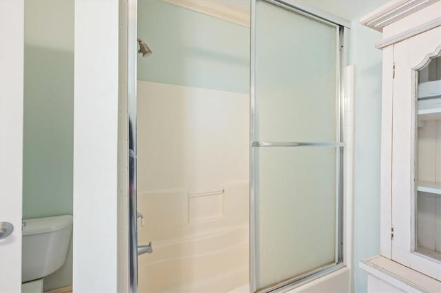 bathroom featuring enclosed tub / shower combo and toilet