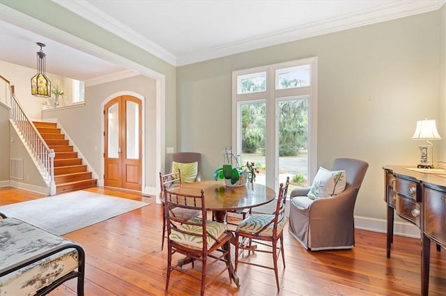 dining space with visible vents, hardwood / wood-style floors, stairway, crown molding, and baseboards