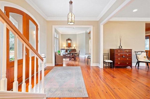 entryway featuring stairs, baseboards, wood finished floors, and crown molding