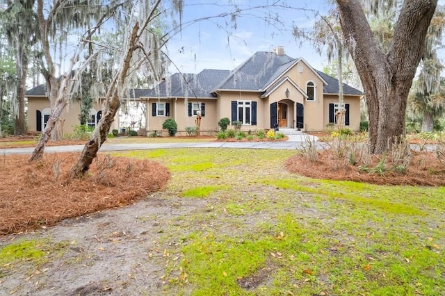 ranch-style house with stucco siding and a front lawn