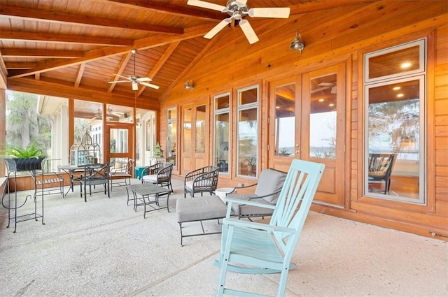 sunroom / solarium with lofted ceiling with beams, wood ceiling, and a ceiling fan