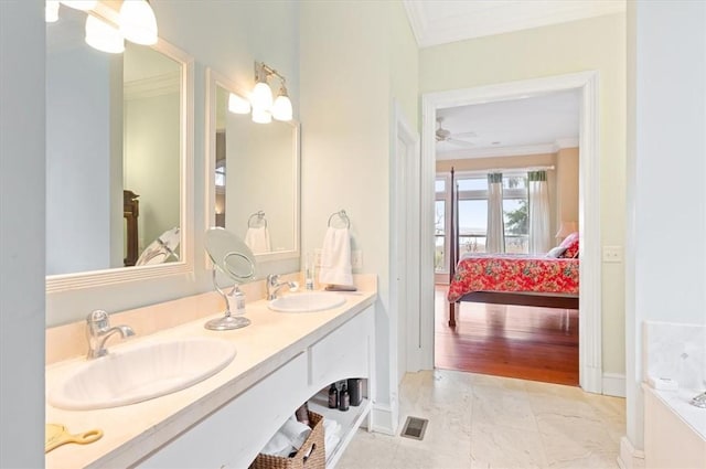 ensuite bathroom with double vanity, ensuite bath, crown molding, and a sink