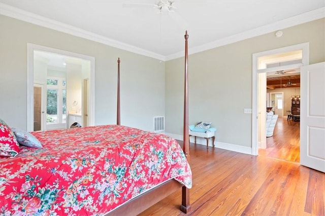 bedroom featuring visible vents, ornamental molding, a ceiling fan, wood finished floors, and baseboards