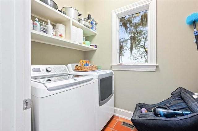 laundry area featuring baseboards, visible vents, laundry area, washer and dryer, and tile patterned floors