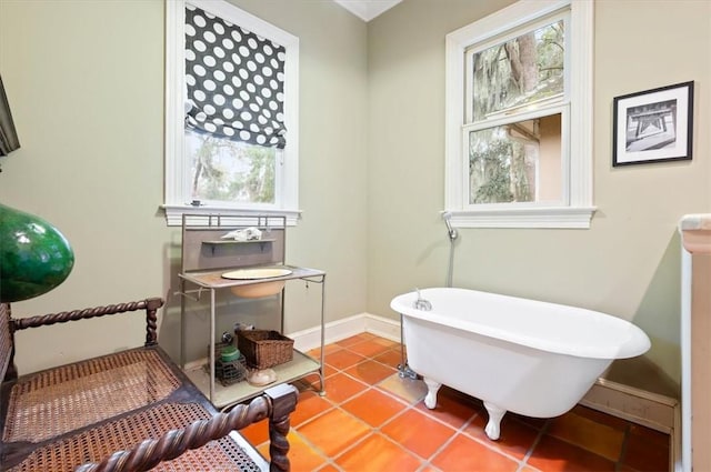 bathroom featuring tile patterned floors, baseboards, and a soaking tub