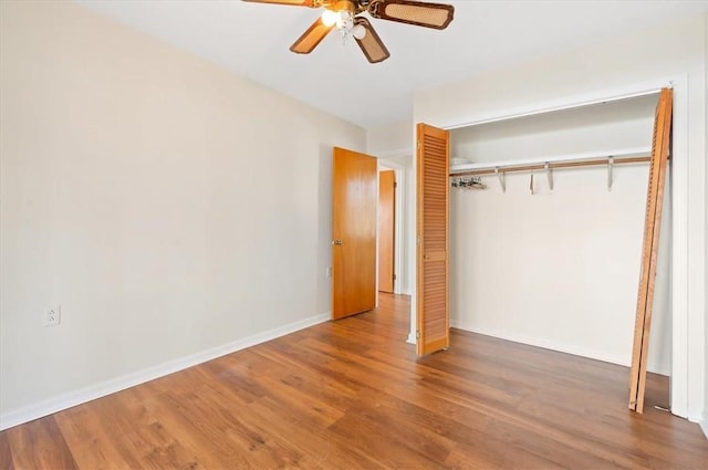 unfurnished bedroom featuring a closet, a ceiling fan, wood finished floors, and baseboards