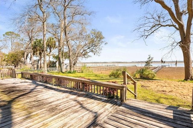 wooden deck with a water view and fence