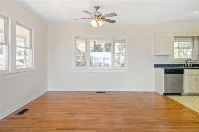 unfurnished dining area featuring a ceiling fan, visible vents, light wood-type flooring, and a sink