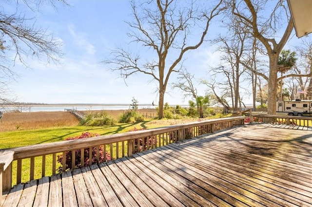 wooden deck with a yard and a water view