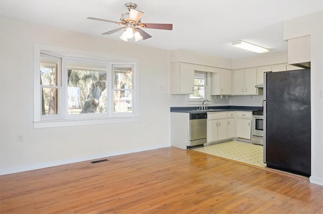 kitchen featuring light wood-type flooring, visible vents, appliances with stainless steel finishes, and a sink