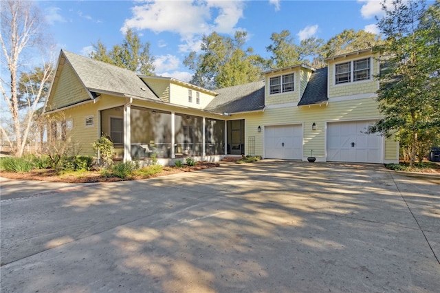 view of front of property featuring a garage and a sunroom