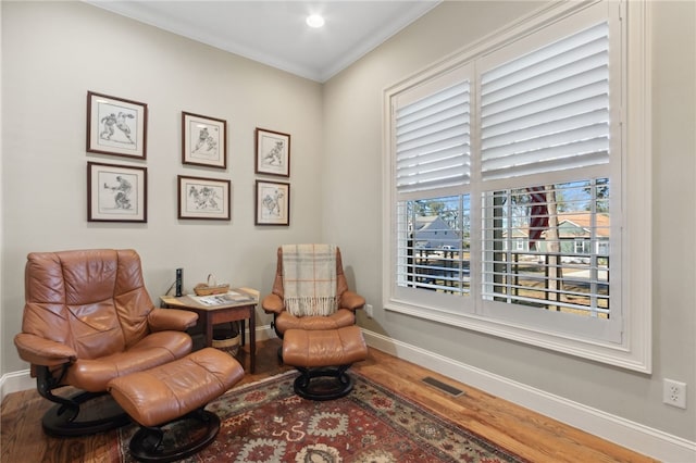 sitting room featuring hardwood / wood-style floors and crown molding