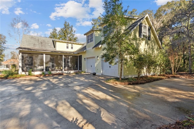 view of front of home featuring a sunroom and a garage