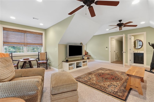 carpeted living room with ceiling fan and vaulted ceiling