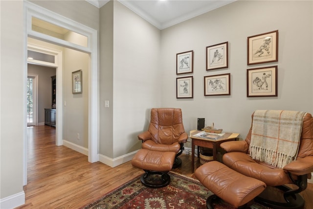 sitting room featuring light hardwood / wood-style flooring and crown molding