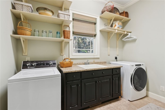 clothes washing area featuring washing machine and dryer, sink, cabinets, and ornamental molding