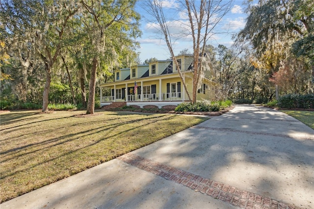 cape cod-style house featuring covered porch and a front lawn