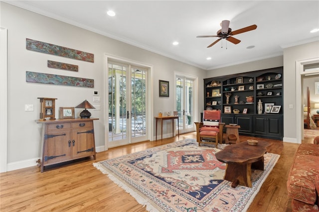 living area featuring ceiling fan, crown molding, and light hardwood / wood-style flooring