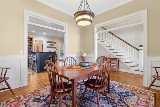 dining space with light wood-type flooring and crown molding