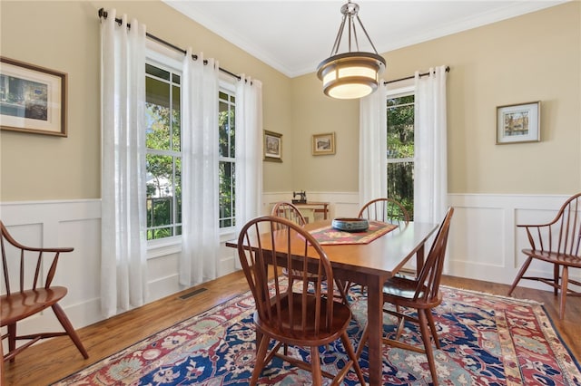 dining space with crown molding and wood-type flooring