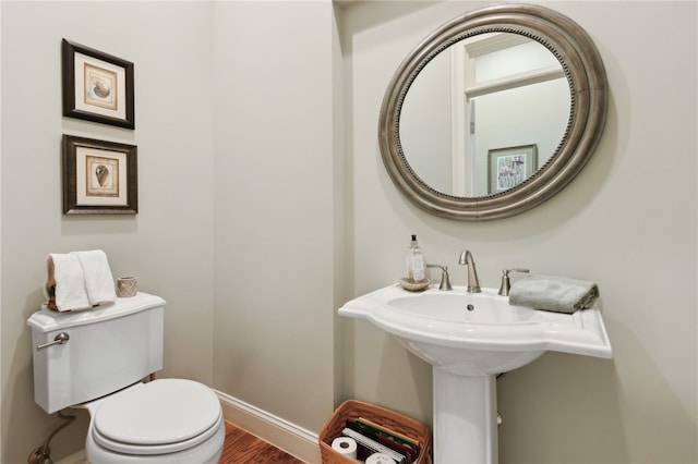 bathroom with hardwood / wood-style floors and toilet