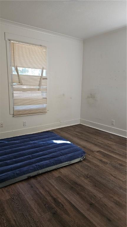 unfurnished room featuring dark wood finished floors and baseboards