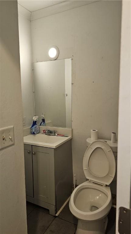 bathroom with toilet, tile patterned flooring, and vanity