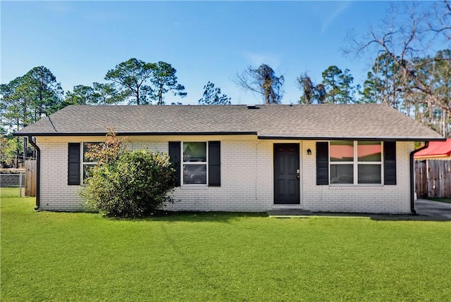 ranch-style house featuring fence, a front yard, and brick siding