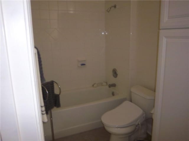 full bathroom featuring toilet, bathing tub / shower combination, and tile patterned flooring